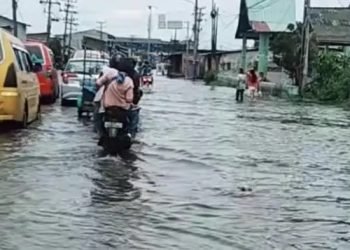Air menggenangi Jalan KL Yos Sudarso simpang Sicanang Kecamatan Medan Belawan yang merupakan jalan utama masuk ke Pelabuhan Belawan. 
