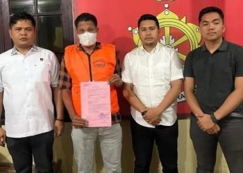 Ronni Bako (rompi orange) diapit petugas. 