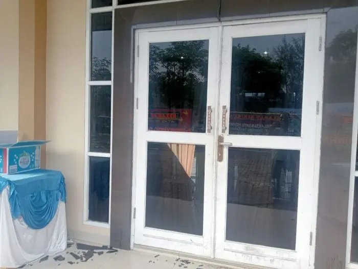 Kaca pintu aula yang pecah akibat kericuhan saat Konferensi Mahasiswa Islam di Lubuk Pakam.