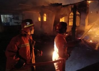 Petugas pemadam kebakaran BPBD menyiram api yang membakar rumah di Jalan Saudara dusun II kecamatan Hamparan Perak Kabupate Deli Serdang.
