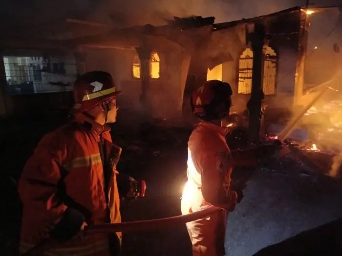 Petugas pemadam kebakaran BPBD menyiram api yang membakar rumah di Jalan Saudara dusun II kecamatan Hamparan Perak Kabupate Deli Serdang.