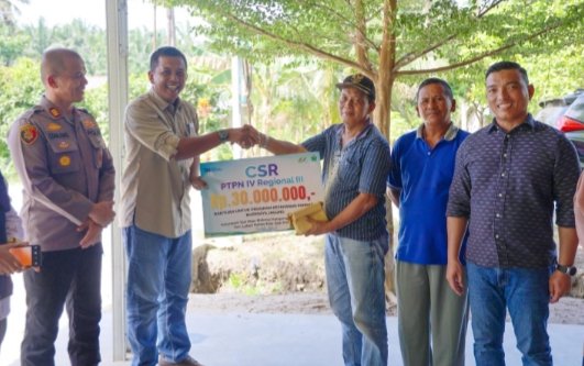 Manajemen PTPN IV Regional III diwakili Manajer Kebun Lubuk Dalam Koko Baskoro menyerahkan bantuan TJSL kepada kelompok tani budidaya jagung di Kabupaten Siak, Riau. (IST)