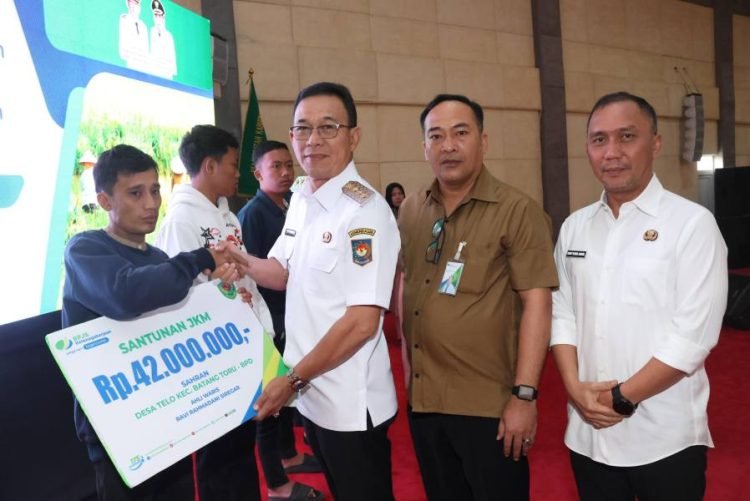 Bupati Tapsel Gus Irawan Pasaribu menyerahkan bantuan JKM  pada salah satu warga. (ist)