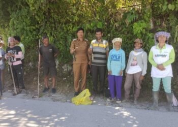 Camat Uluan Juni Hanmas Butarbutar didampingi Lion Manurung Kepala Desa Partoruan Janjimatogu foto bersama dengan para petani saat berburu tikus di Janjimatogu. (IST)