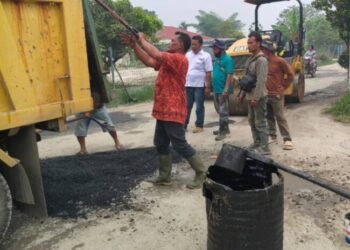 Dinas PUTR Kabupaten Toba Sedang menutup lubang sepanjang ruas jalan Porsea Siregar menuju Desa Lbn. Binanga Kec . Uluan. (IST)