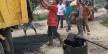 Dinas PUTR Kabupaten Toba Sedang menutup lubang sepanjang ruas jalan Porsea Siregar menuju Desa Lbn. Binanga Kec . Uluan. (IST)