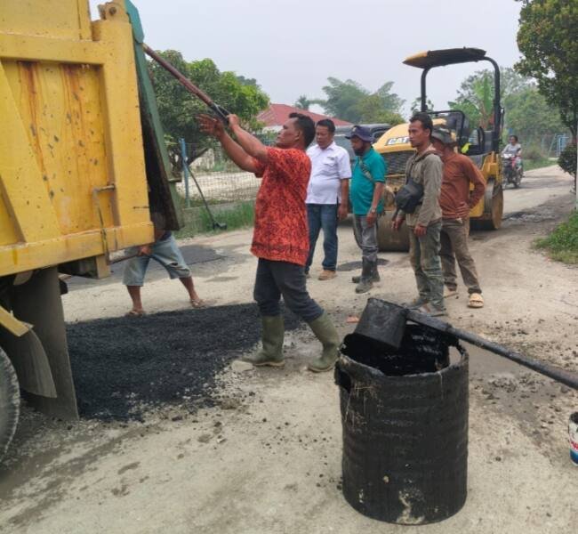 Dinas PUTR Kabupaten Toba Sedang menutup lubang sepanjang ruas jalan Porsea Siregar menuju Desa Lbn. Binanga Kec . Uluan. (IST)